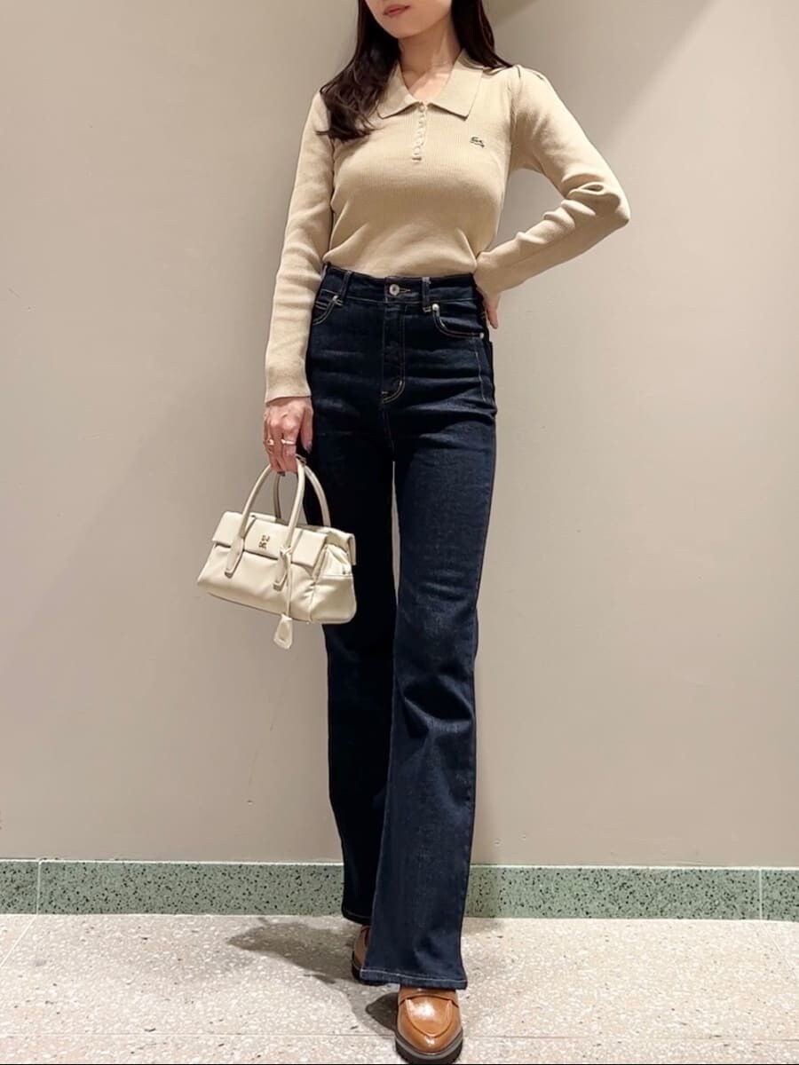 ホワイト系のダウンジャケット/コート、イエロー系のニット/セーター、ブルー系のその他パンツを着用したレディースの秋コーディネートの6枚目の写真