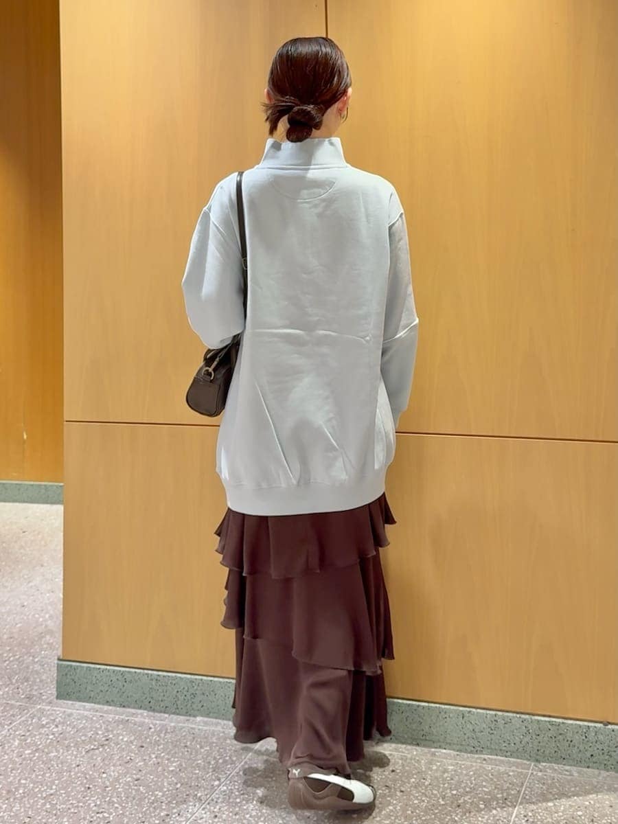 ブラウン系のスカートを着用したレディースの秋コーディネートの3枚目の写真