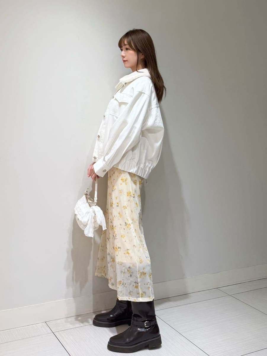 ブラウン系のブーツ、ホワイト系のブルゾン、イエロー系のワンピースを着用したレディースの冬コーディネートの2枚目の写真