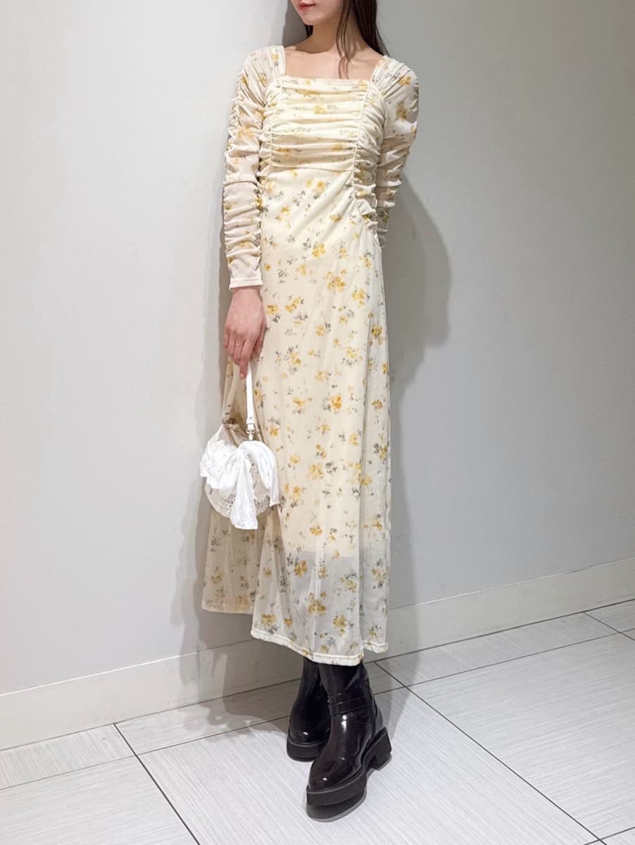 ブラウン系のブーツ、ホワイト系のブルゾン、イエロー系のワンピースを着用したレディースの冬コーディネートの3枚目の写真