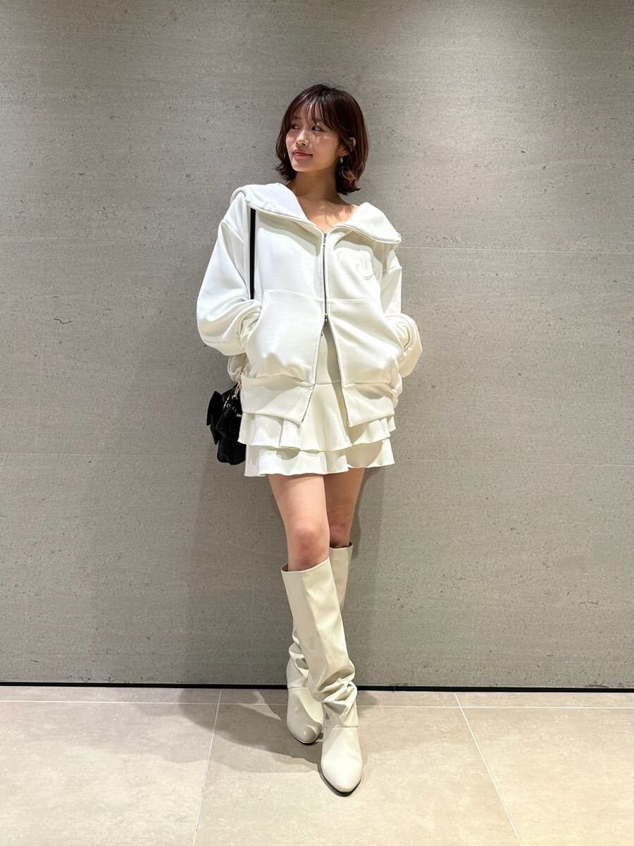 ホワイト系のパーカー、ホワイト系のブーツ、ブラック系のショルダーバッグを着用したレディースの冬コーディネートの5枚目の写真