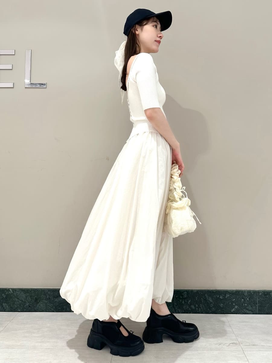 ブラック系のスニーカー、ブルー系のキャップを着用したレディースの春コーディネートの3枚目の写真