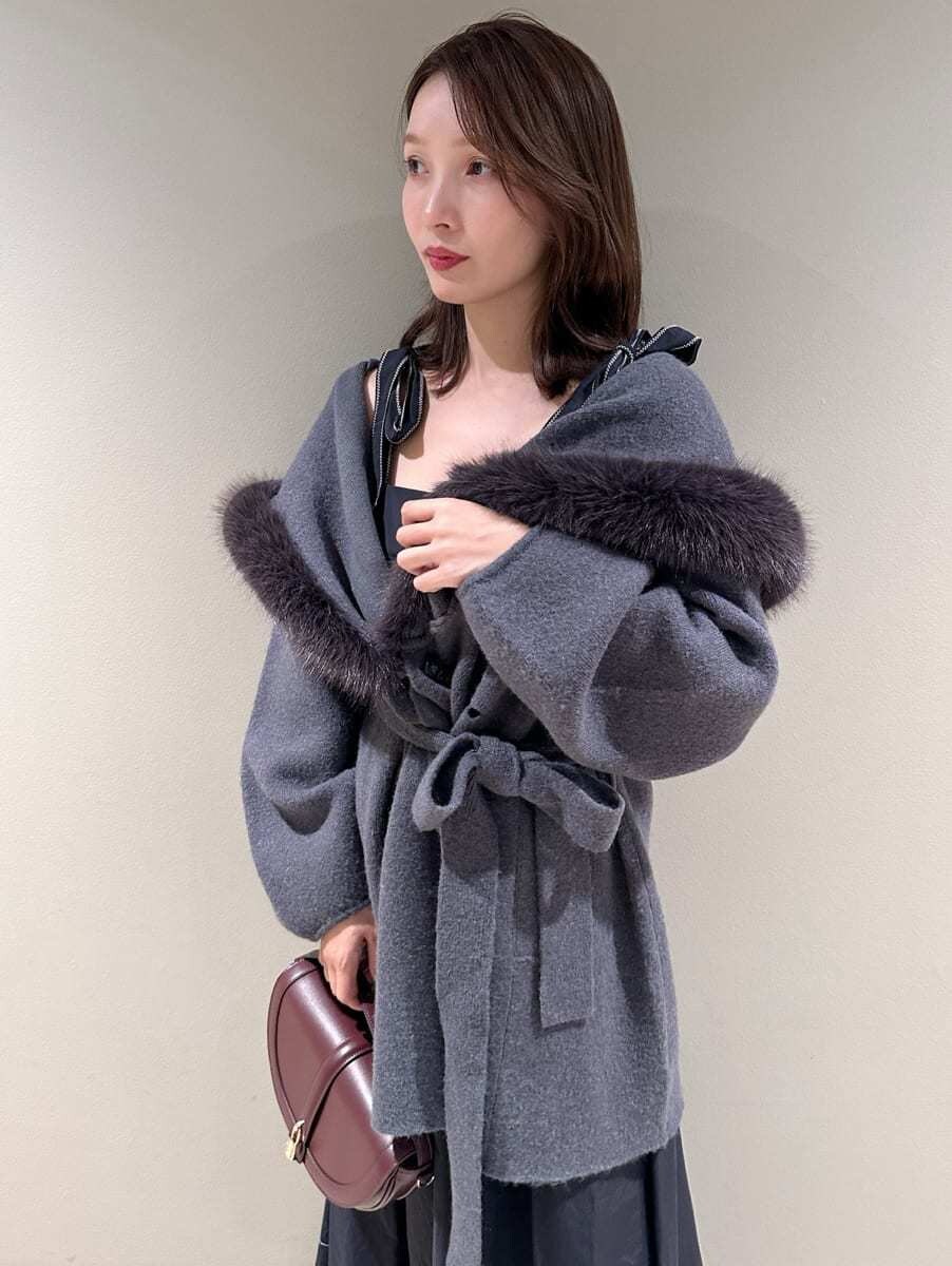 ブラック系のワンピース、ブラウン系のハンドバッグ、ブラック系のブーツを着用したレディースの秋コーディネートの5枚目の写真