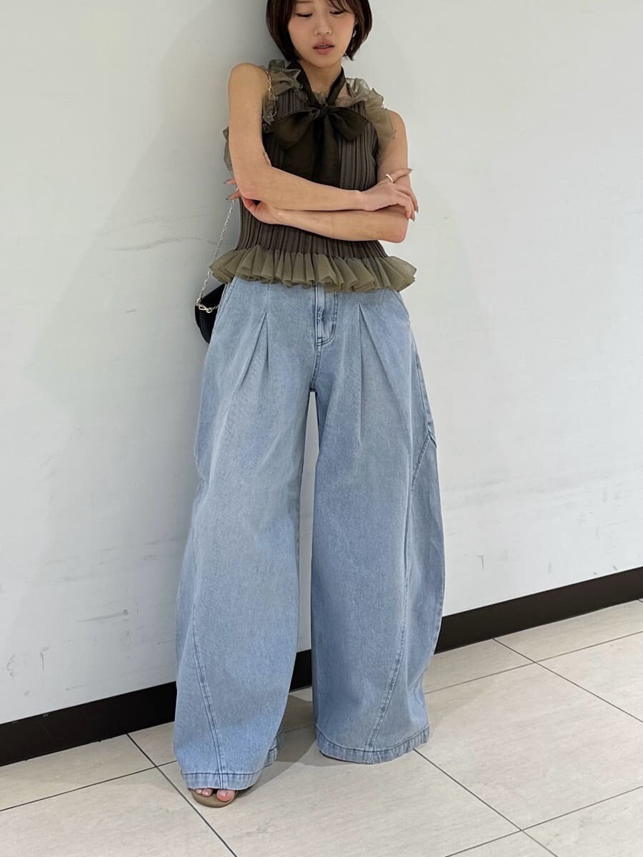 ブラック系のショルダーバッグ、ブルー系のデニムパンツ、グリーン系のニット/セーターを着用したレディースの夏コーディネートの5枚目の写真