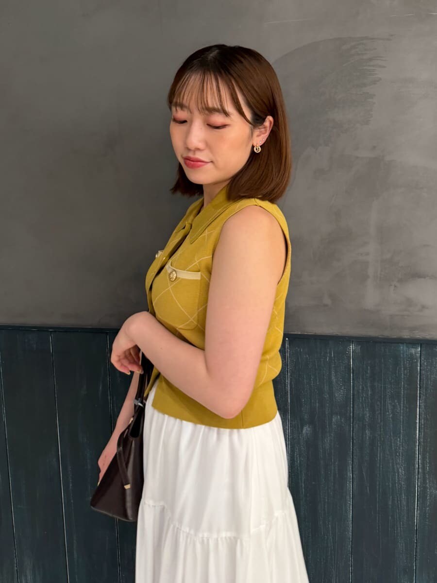 イエロー系のワンピース、ブラウン系のサンダル、ブラウン系のボストンバッグを着用したレディースの夏コーディネートの6枚目の写真