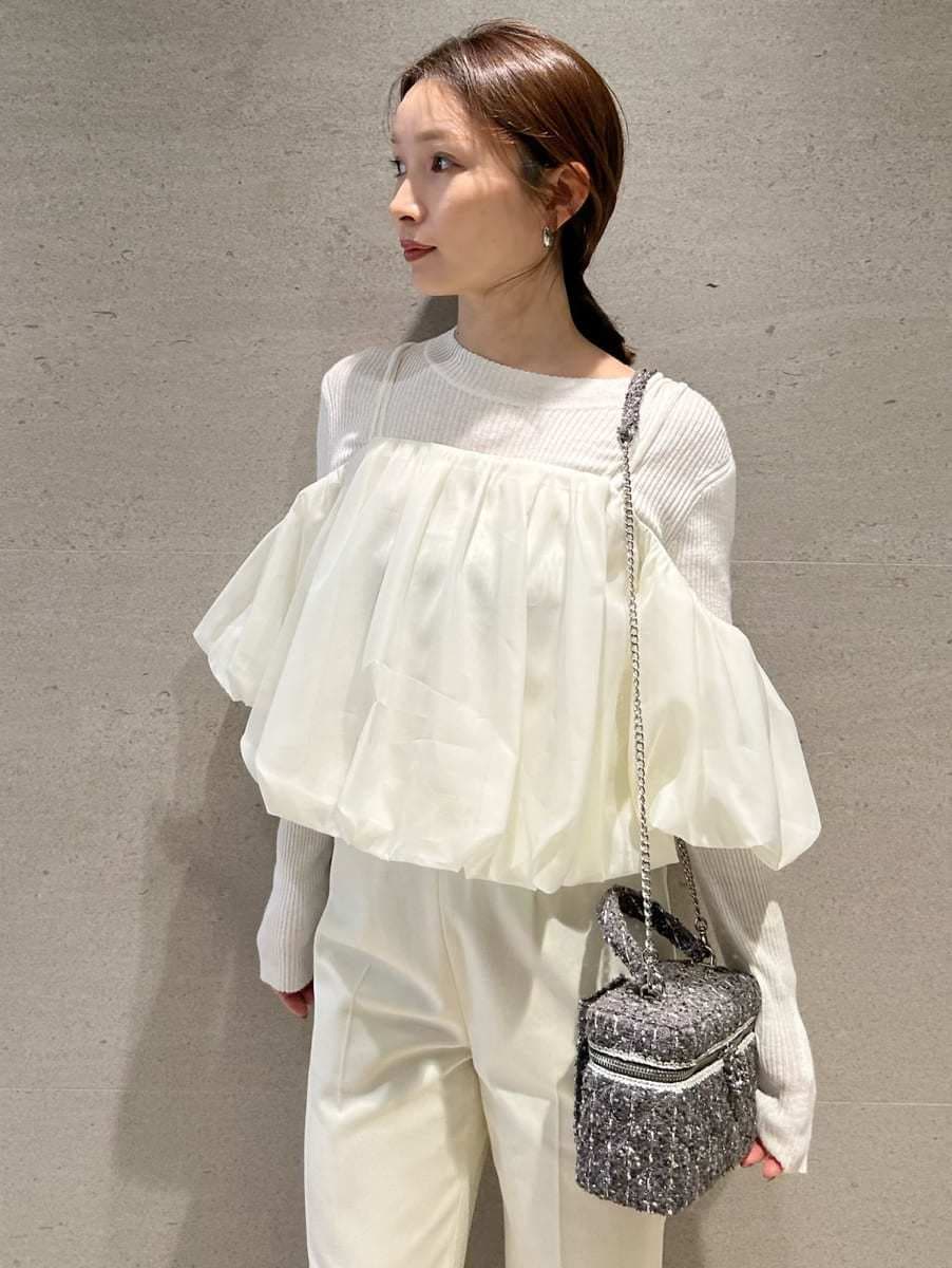 ブラウン系のブーツ、ホワイト系のスラックス、ホワイト系のニット/セーターを着用したレディースの秋コーディネートの5枚目の写真