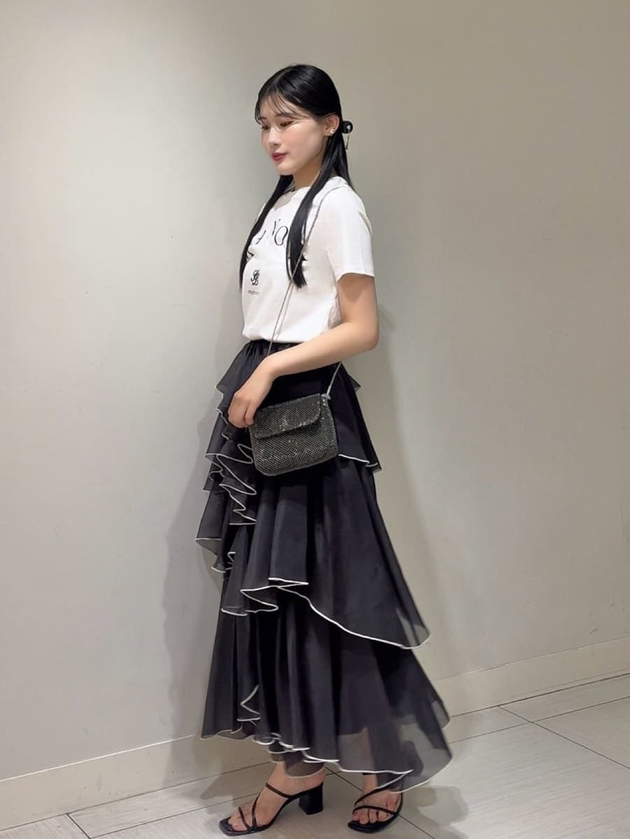 ブラック系のサンダル、ブラック系のスカート、ホワイト系のTシャツ/カットソーを着用したレディースの夏コーディネートの2枚目の写真