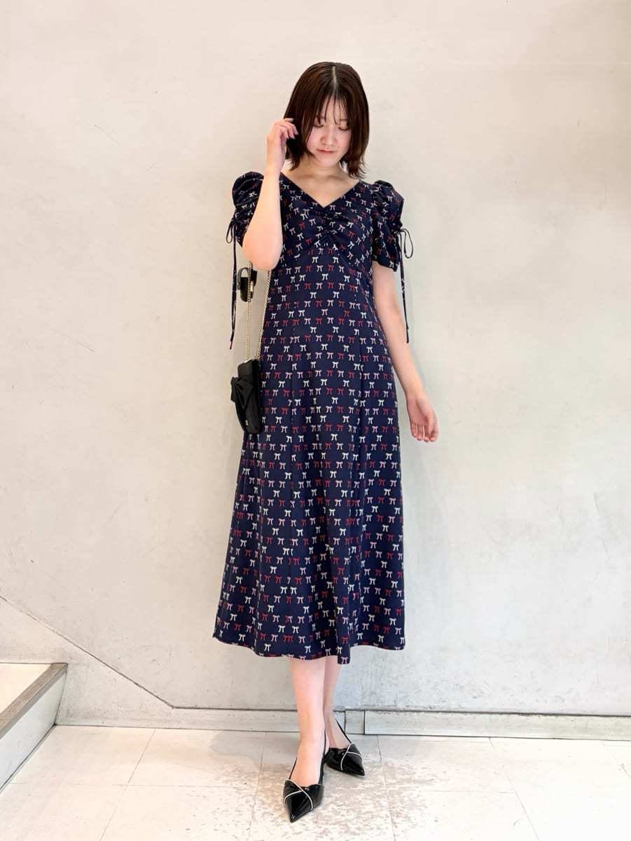 ブルー系のワンピース、ブラック系のパンプス、ブラック系のショルダーバッグを着用したレディースの冬コーディネートの2枚目の写真