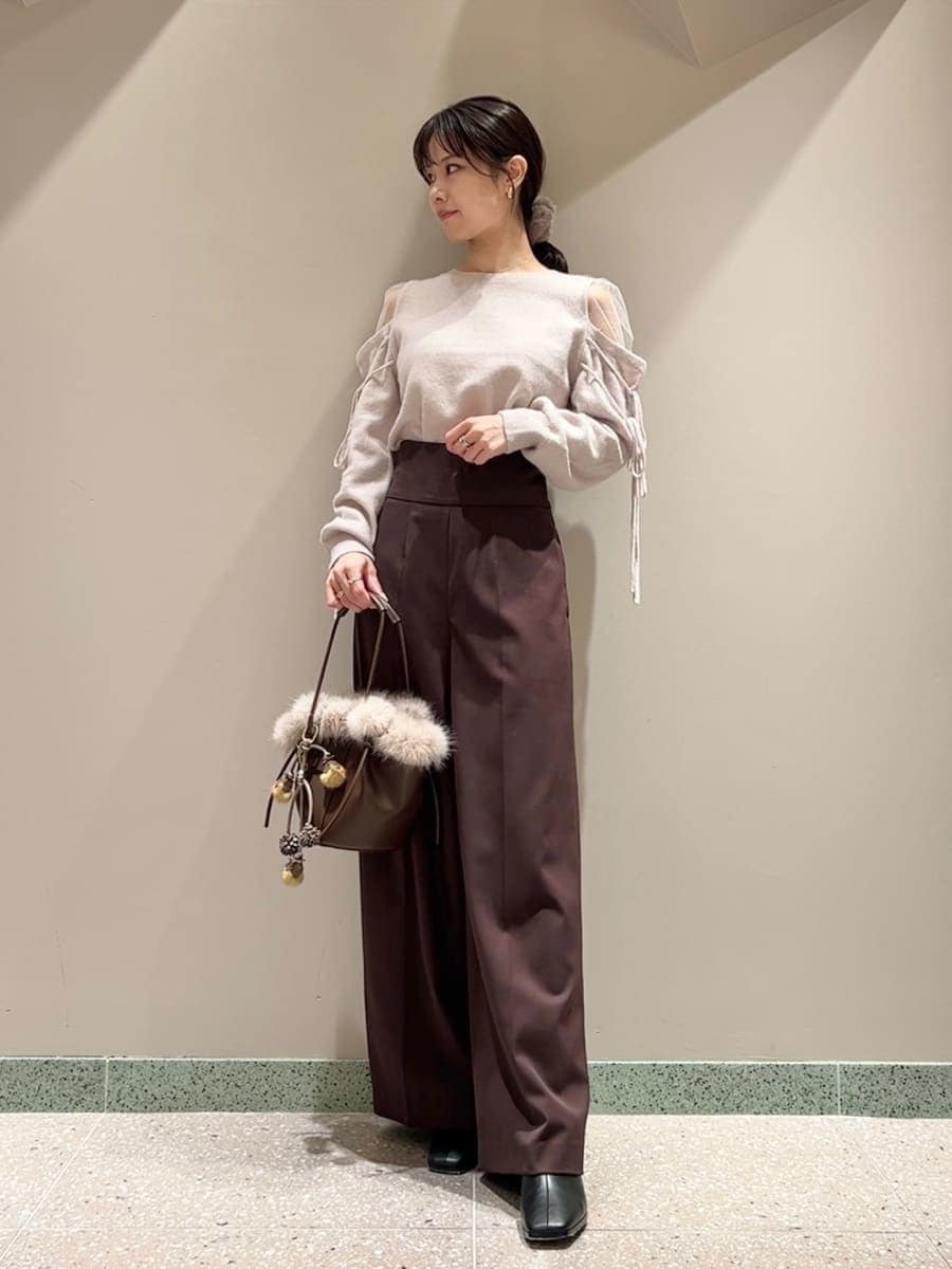 ブラウン系のスラックス、ピンク系のニット/セーター、ブラウン系のハンドバッグを着用したレディースの冬コーディネートの3枚目の写真