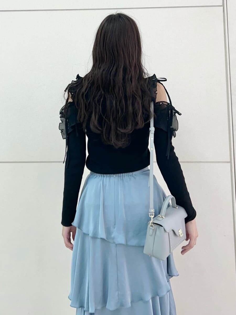 ブラック系のニット/セーター、ブルー系のスカート、ブルー系のショルダーバッグを着用したレディースの秋コーディネートの7枚目の写真