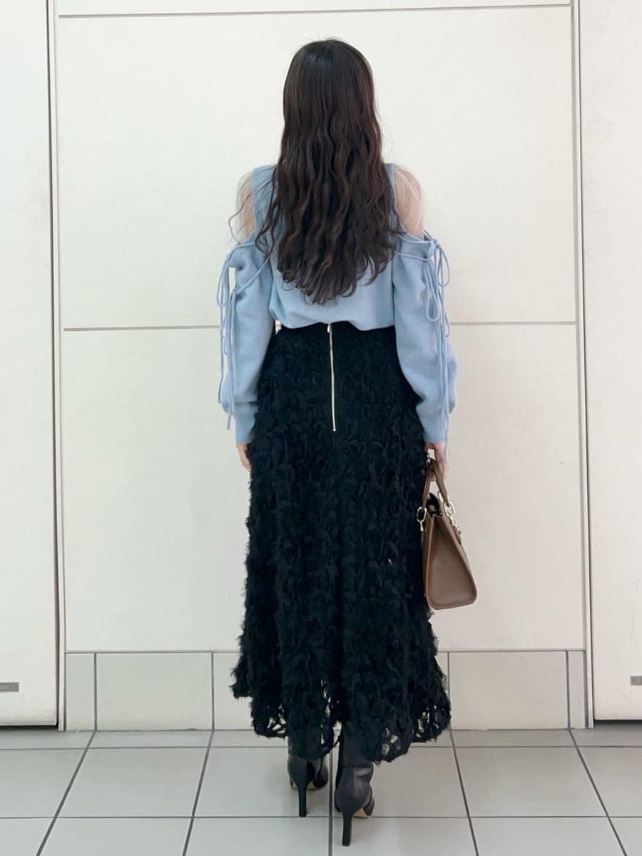 ブラック系のブーツ、ブラック系のスカート、ブルー系のニット/セーターを着用したレディースの冬コーディネートの4枚目の写真