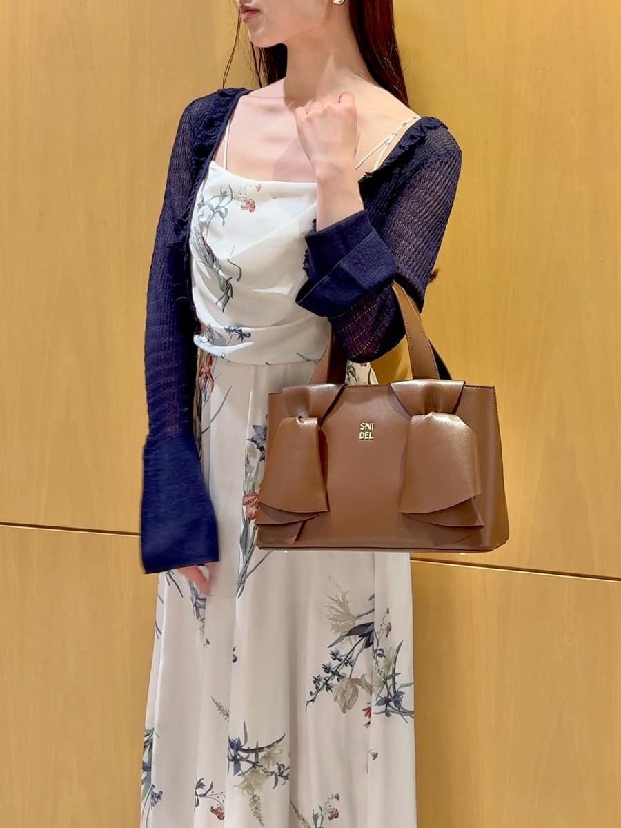 ブルー系のカーディガン/ボレロ、ホワイト系のワンピース、ブラウン系のハンドバッグを着用したレディースの冬コーディネートの9枚目の写真