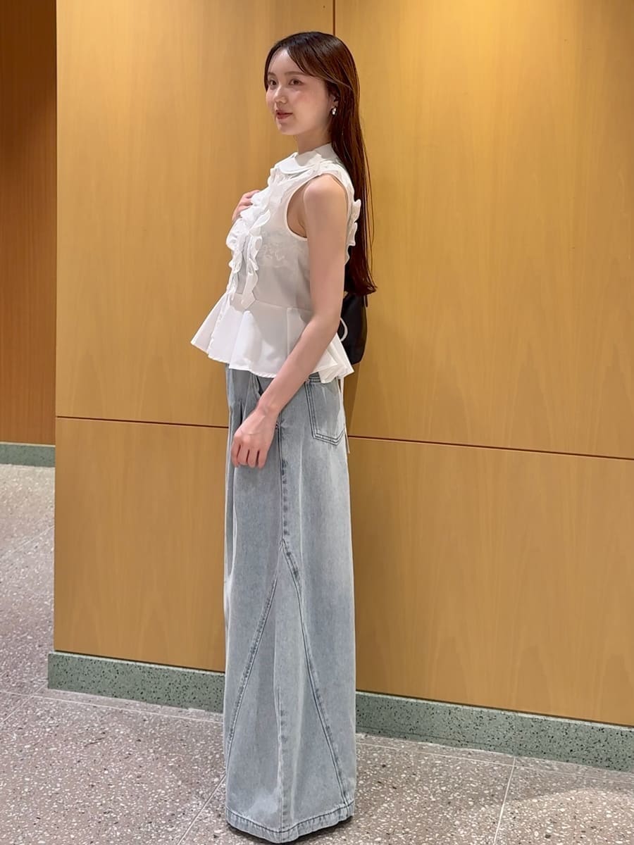 ブルー系のデニムパンツ、ブラック系のサンダル、ブラック系のショルダーバッグを着用したレディースの夏コーディネートの2枚目の写真