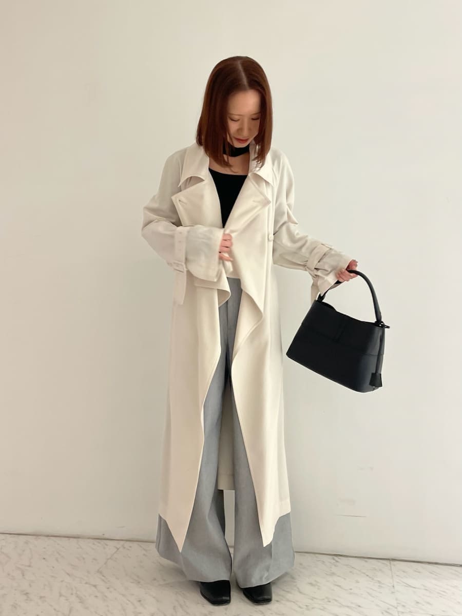 ブラック系のショルダーバッグ、ブラック系のニット/セーター、ホワイト系のトレンチコートを着用したレディースの冬コーディネートの5枚目の写真