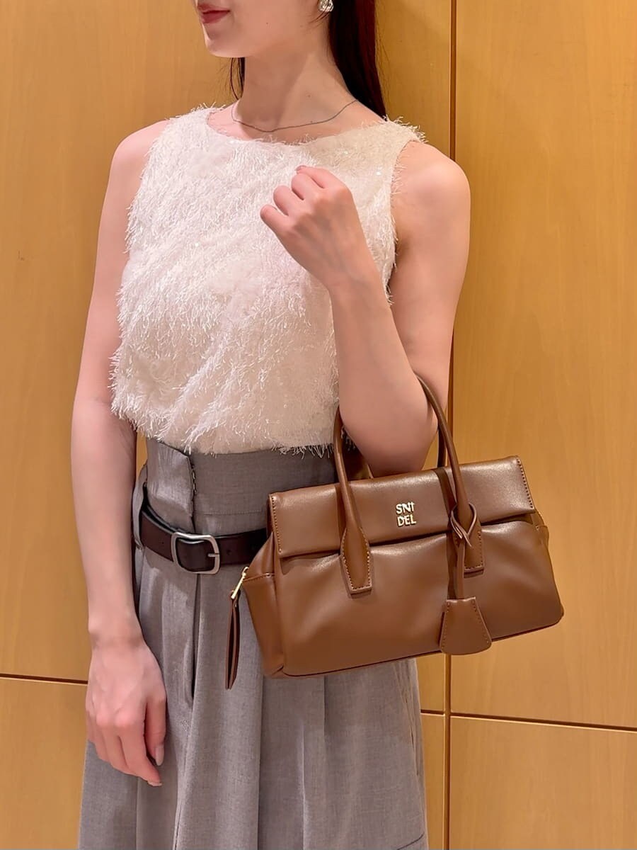 グレー系のスカート、その他のサンダル、ブラウン系のボストンバッグを着用したレディースの夏コーディネートの6枚目の写真