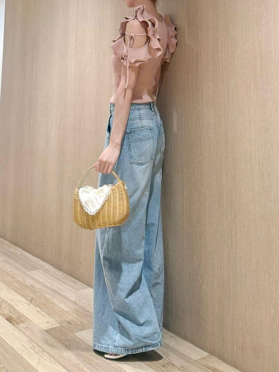 ホワイト系のかごバッグ、ブルー系のデニムパンツ、ピンク系のニット/セーターを着用したレディースの夏コーディネートの2枚目の写真