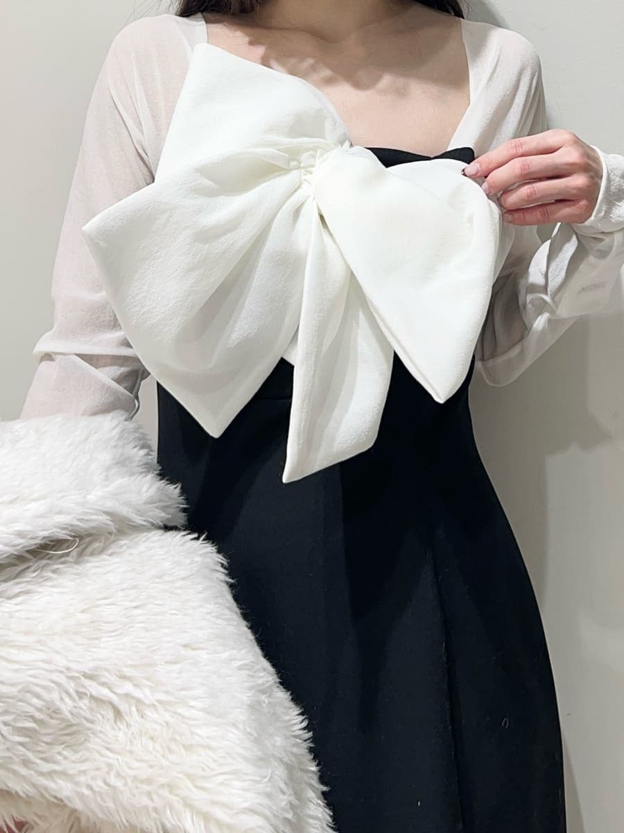 ブラック系のブーツ、ホワイト系のムートンコート、ブラック系のワンピースを着用したレディースの冬コーディネートの2枚目の写真