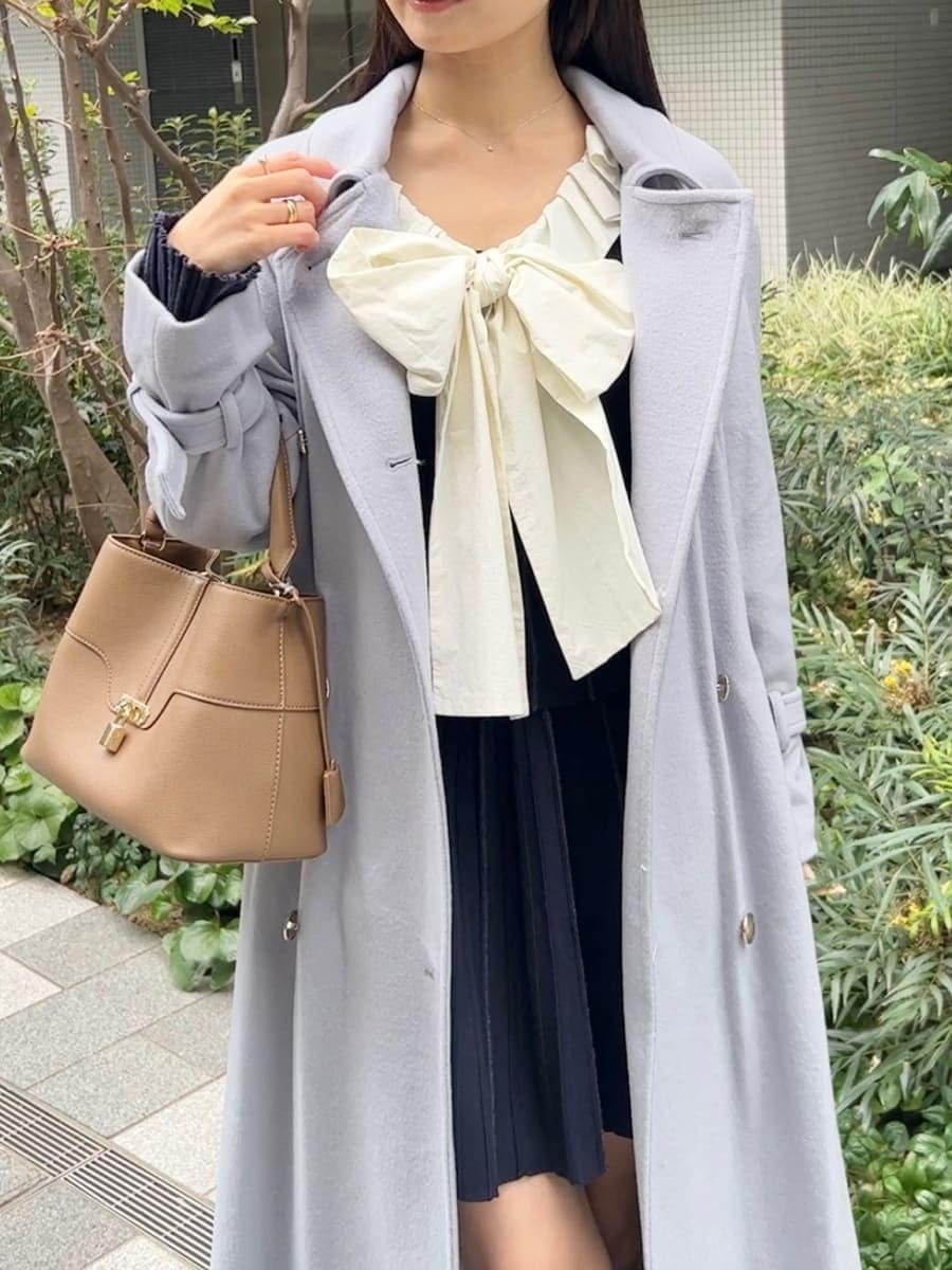 ブラック系のブーツ、ブルー系のチェスターコート、ブルー系のワンピースを着用したレディースの冬コーディネートの3枚目の写真