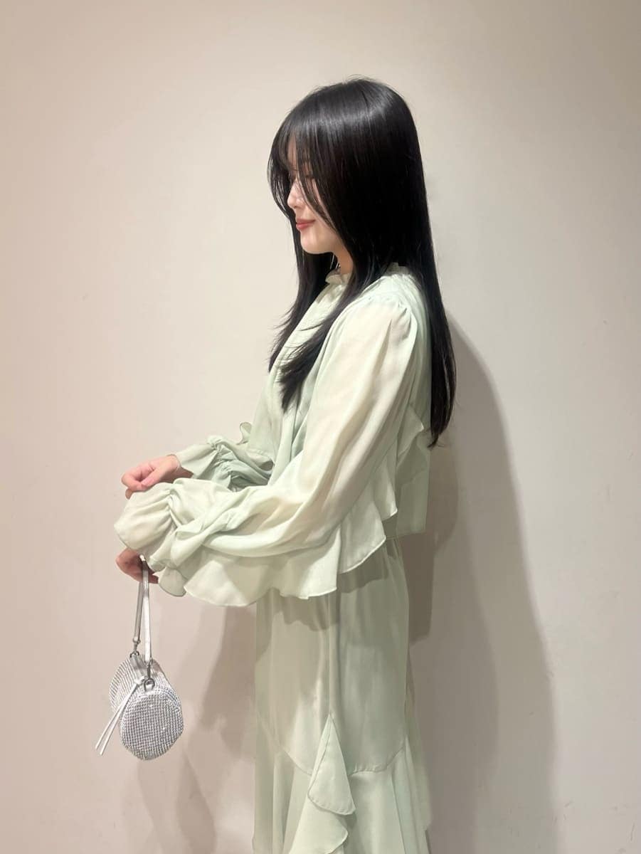 ブラック系のブーツ、ベージュ系のピーコート、グリーン系のワンピースを着用したレディースの冬コーディネートの8枚目の写真