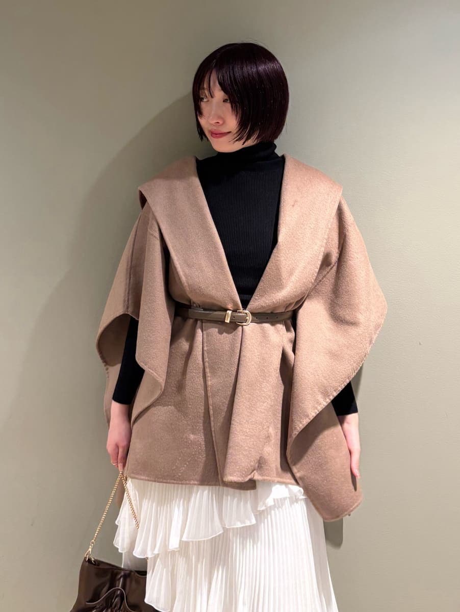 イエロー系のその他アウター、ホワイト系のスカート、ブラック系のニット/セーターを着用したレディースの秋コーディネートの6枚目の写真
