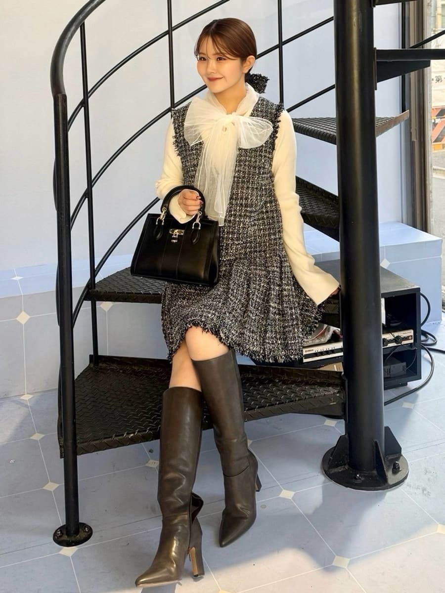 グレー系のブーツ、ブルー系のワンピース、ブラック系のハンドバッグを着用したレディースの冬コーディネートの6枚目の写真