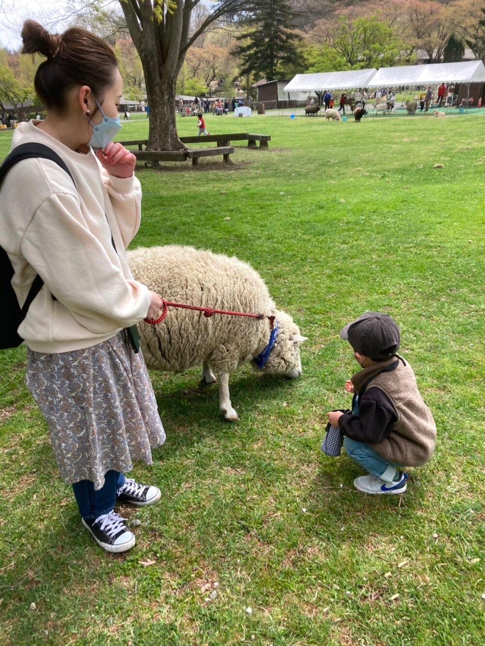 ブルー系のデニムパンツ、ブラウン系のベスト、ブラック系のスニーカーを着用したレディースの春コーディネートの2枚目の写真