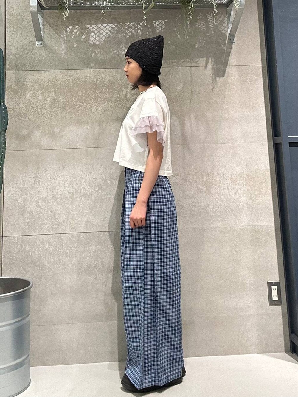 ブルー系のスラックス、ホワイト系のTシャツ/カットソー、ブラック系のニットキャップ/ビーニーを着用したレディースの春コーディネートの2枚目の写真