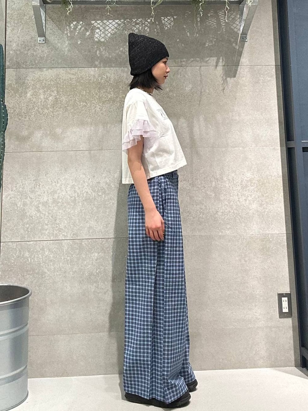 ブルー系のスラックス、ホワイト系のTシャツ/カットソー、ブラック系のニットキャップ/ビーニーを着用したレディースの春コーディネートの3枚目の写真