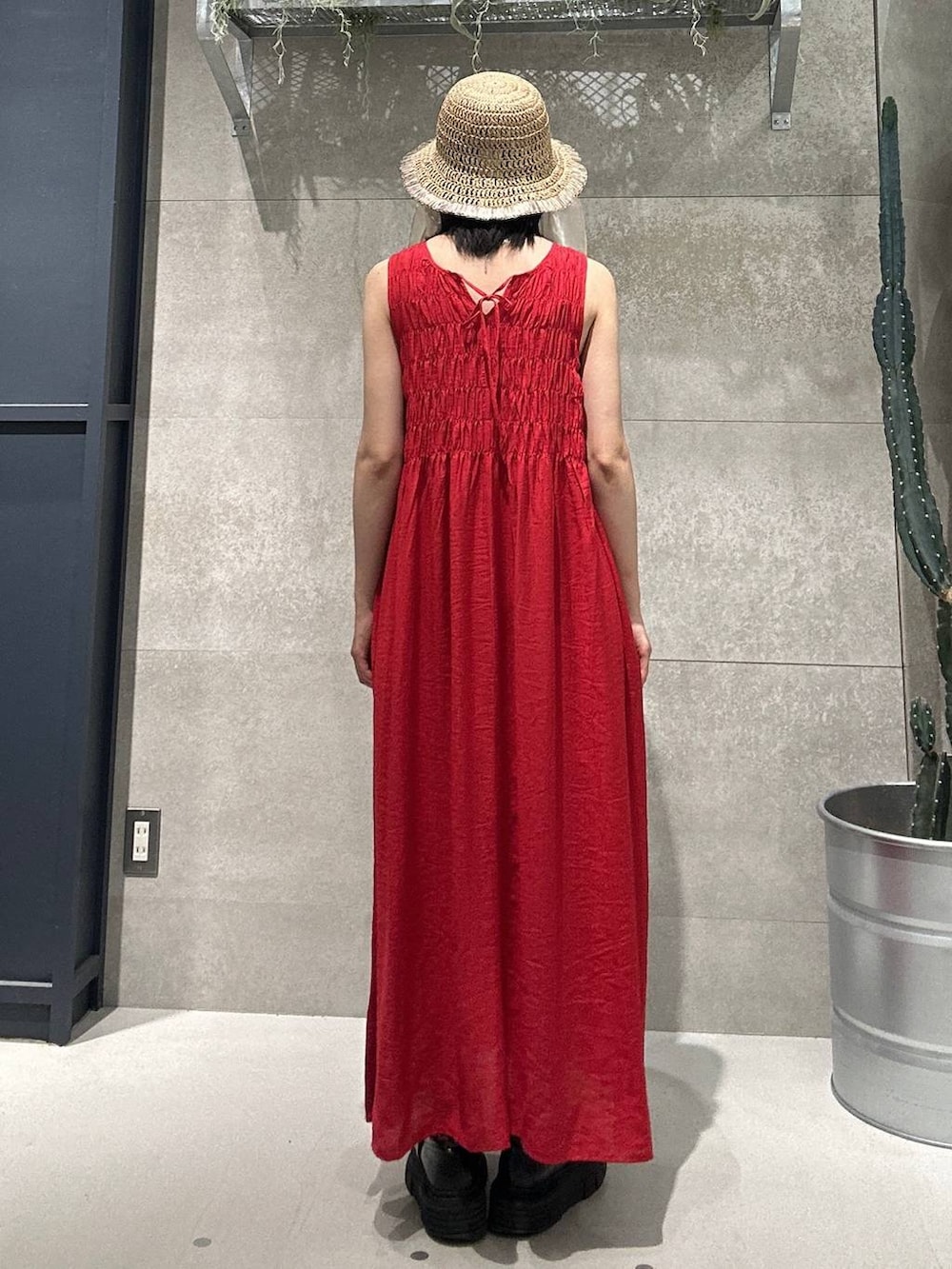 レッド系のワンピース、ブラウン系のハットを着用したレディースの夏コーディネートの4枚目の写真