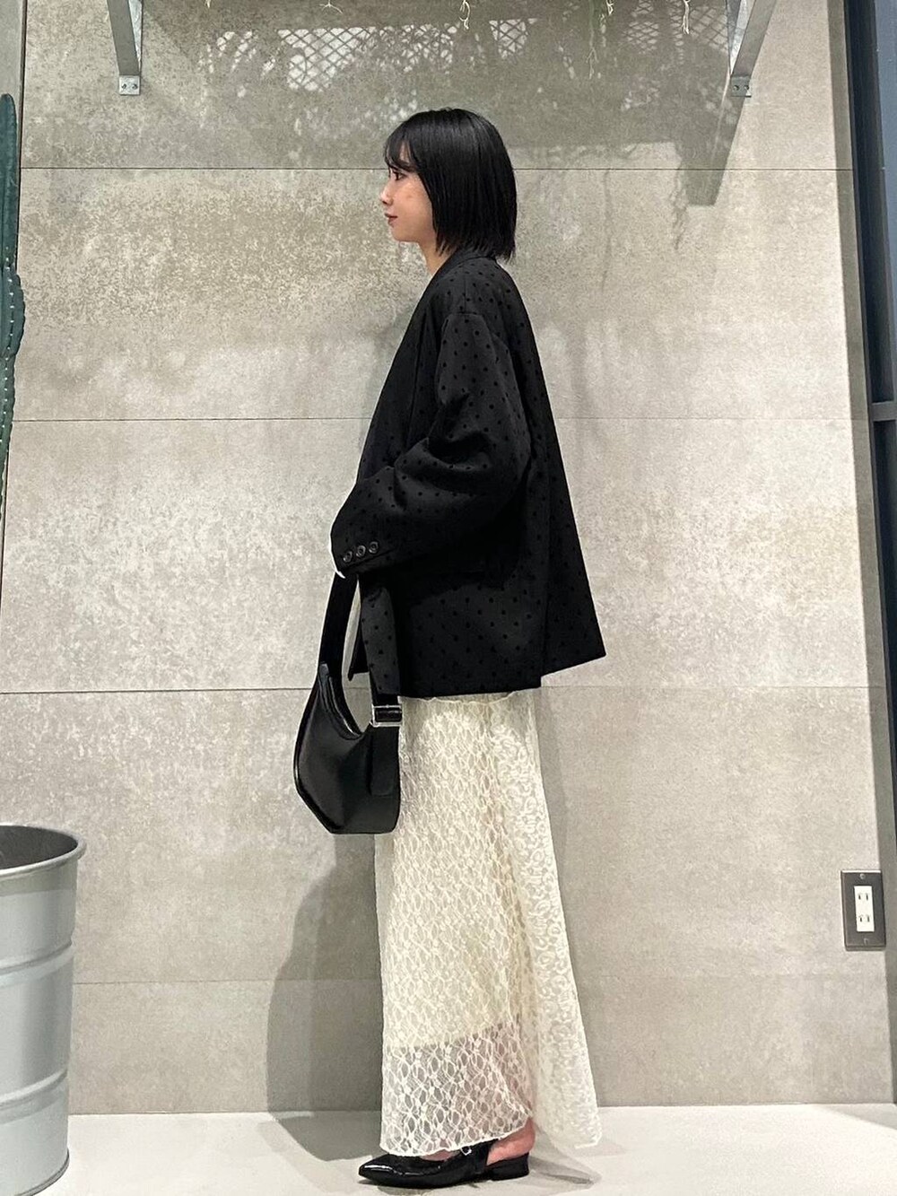 ブラック系のパンプス、ホワイト系のTシャツ/カットソー、ブラック系のショルダーバッグを着用したレディースの冬コーディネートの3枚目の写真