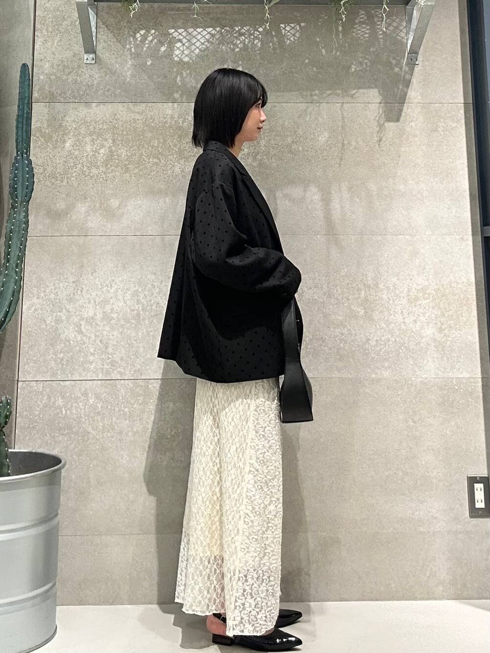 ブラック系のパンプス、ホワイト系のTシャツ/カットソー、ブラック系のショルダーバッグを着用したレディースの冬コーディネートの2枚目の写真