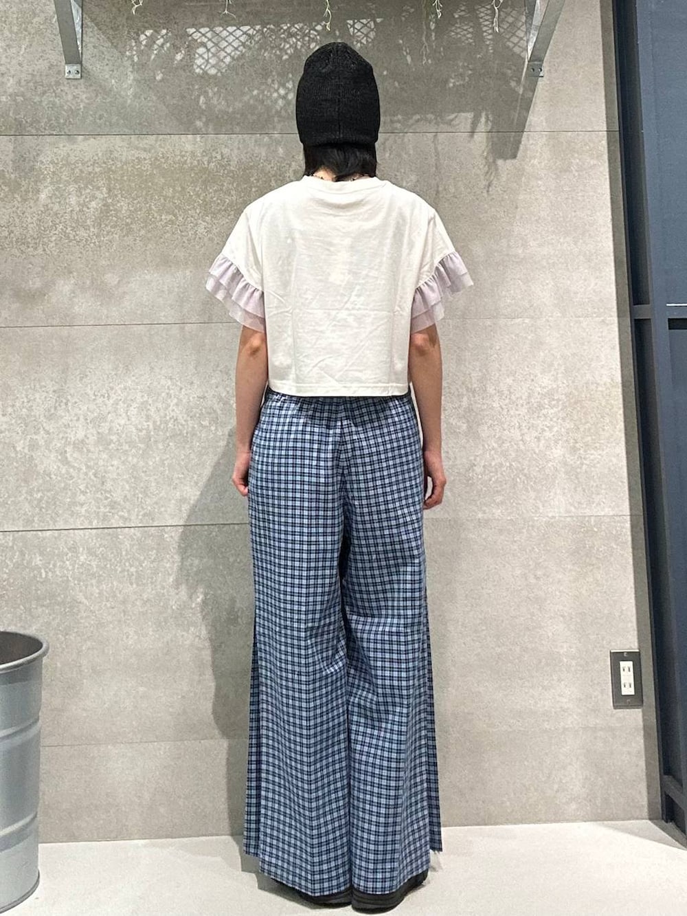 ブルー系のスラックス、ホワイト系のTシャツ/カットソー、ブラック系のニットキャップ/ビーニーを着用したレディースの春コーディネートの4枚目の写真