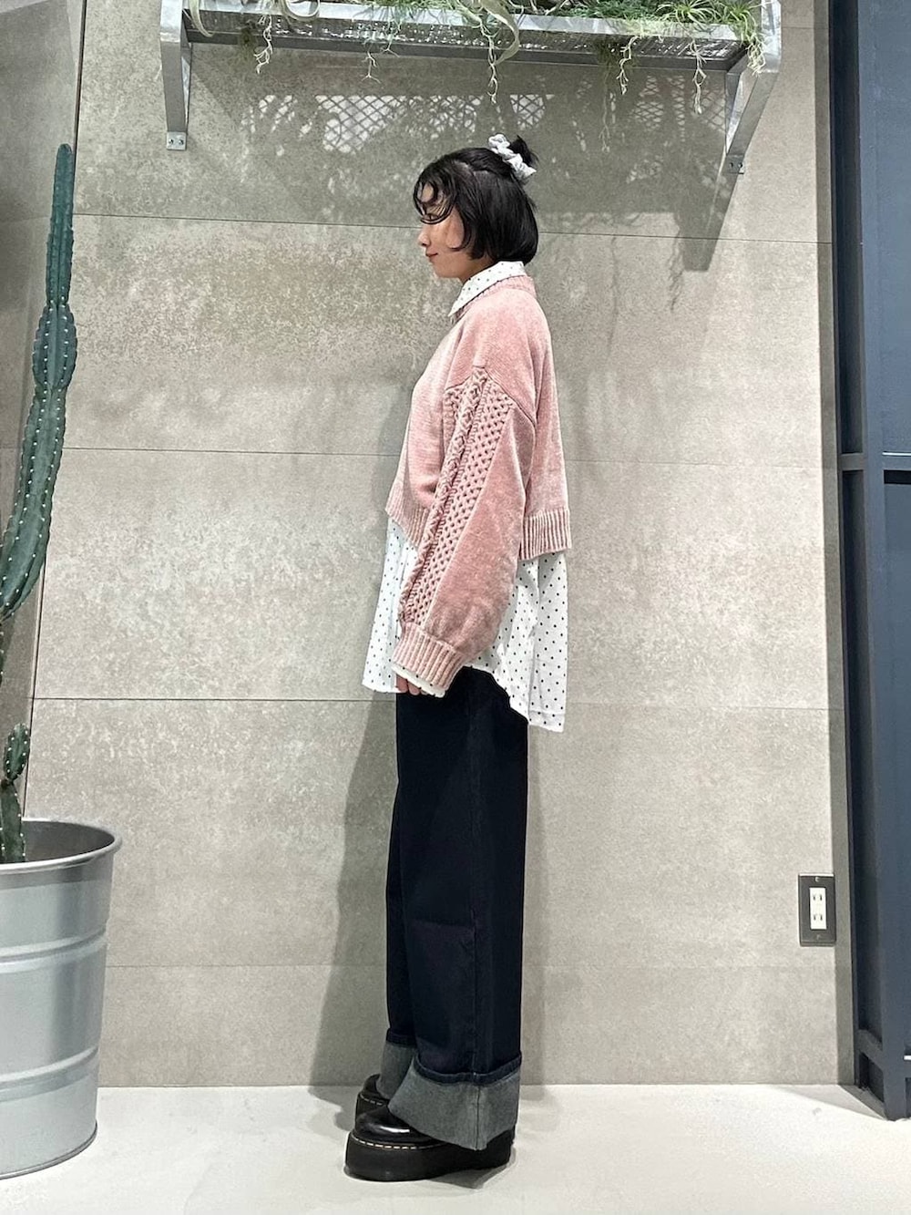 ピンク系のニット/セーター、ブルー系のデニムパンツ、ホワイト系のシャツ/ブラウスを着用したレディースの冬コーディネートの2枚目の写真