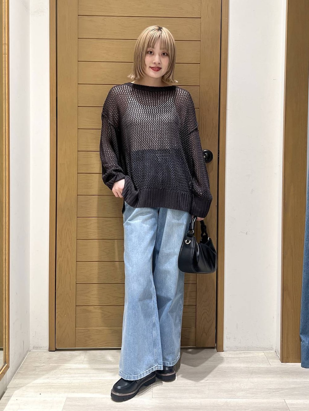 ブルー系のデニムパンツ、ブラック系のハンドバッグ、ブラック系のローファーを着用したレディースの春コーディネートの4枚目の写真