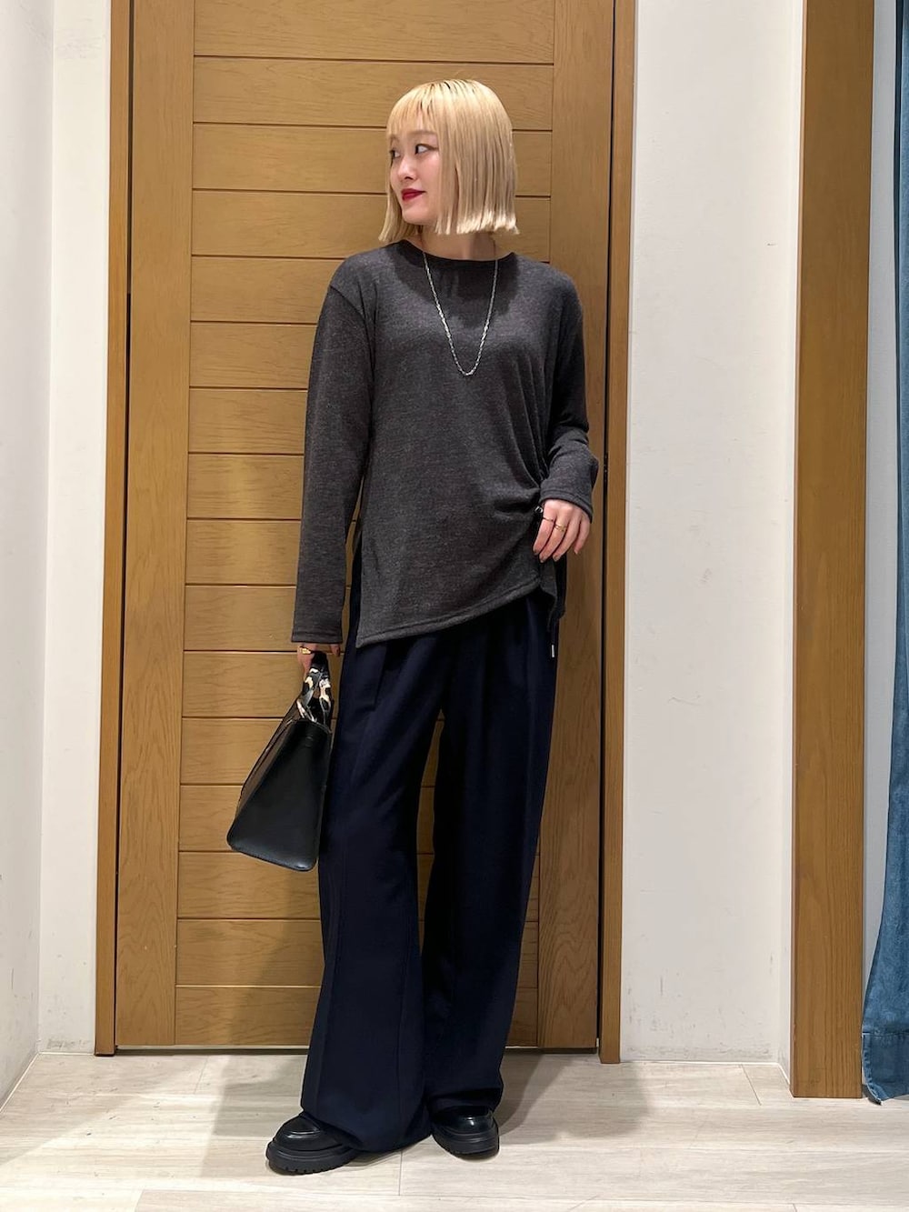 ブラック系のハンドバッグ、ブルー系のその他パンツ、その他のローファーを着用したレディースの冬コーディネートの6枚目の写真