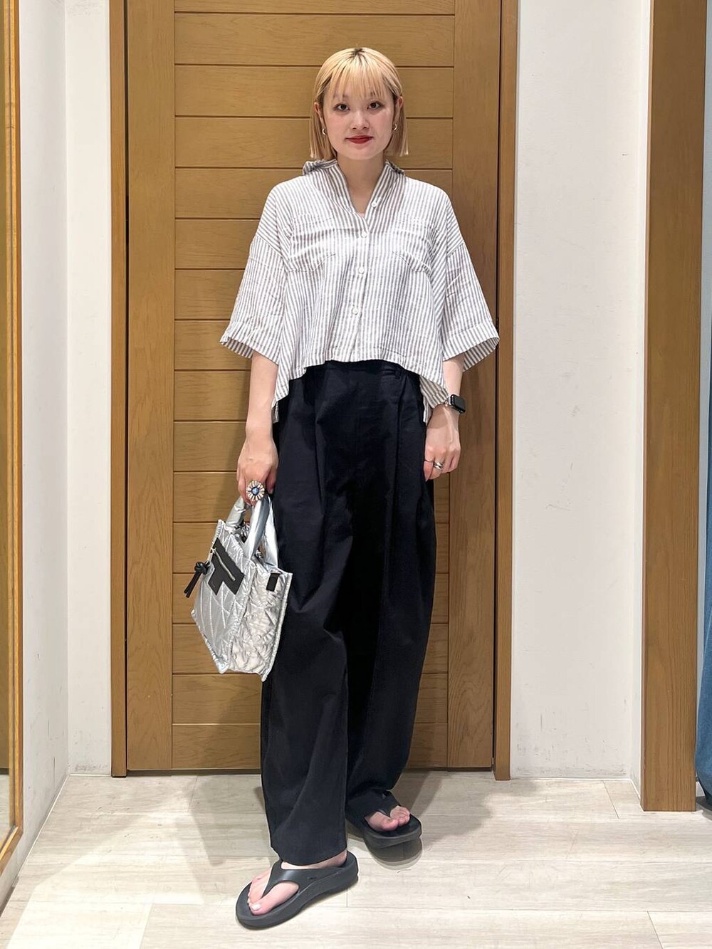 シルバー系のショルダーバッグ、グレー系のシャツ/ブラウス、ブラック系のその他パンツを着用したレディースの夏コーディネートの2枚目の写真