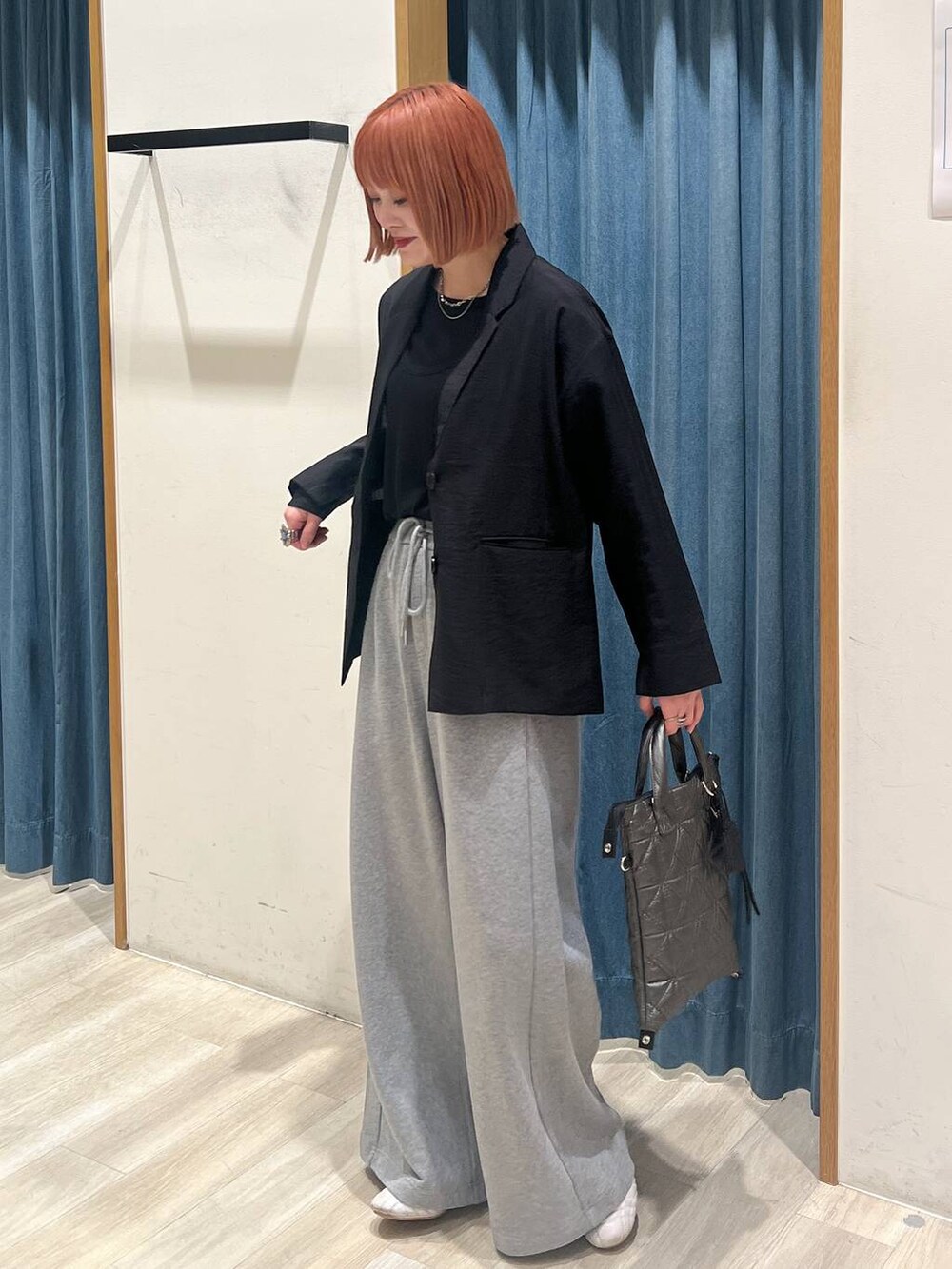 ブラック系のTシャツ/カットソー、ブルー系のハンドバッグ、グレー系のスウェットパンツを着用したレディースの春コーディネートの2枚目の写真