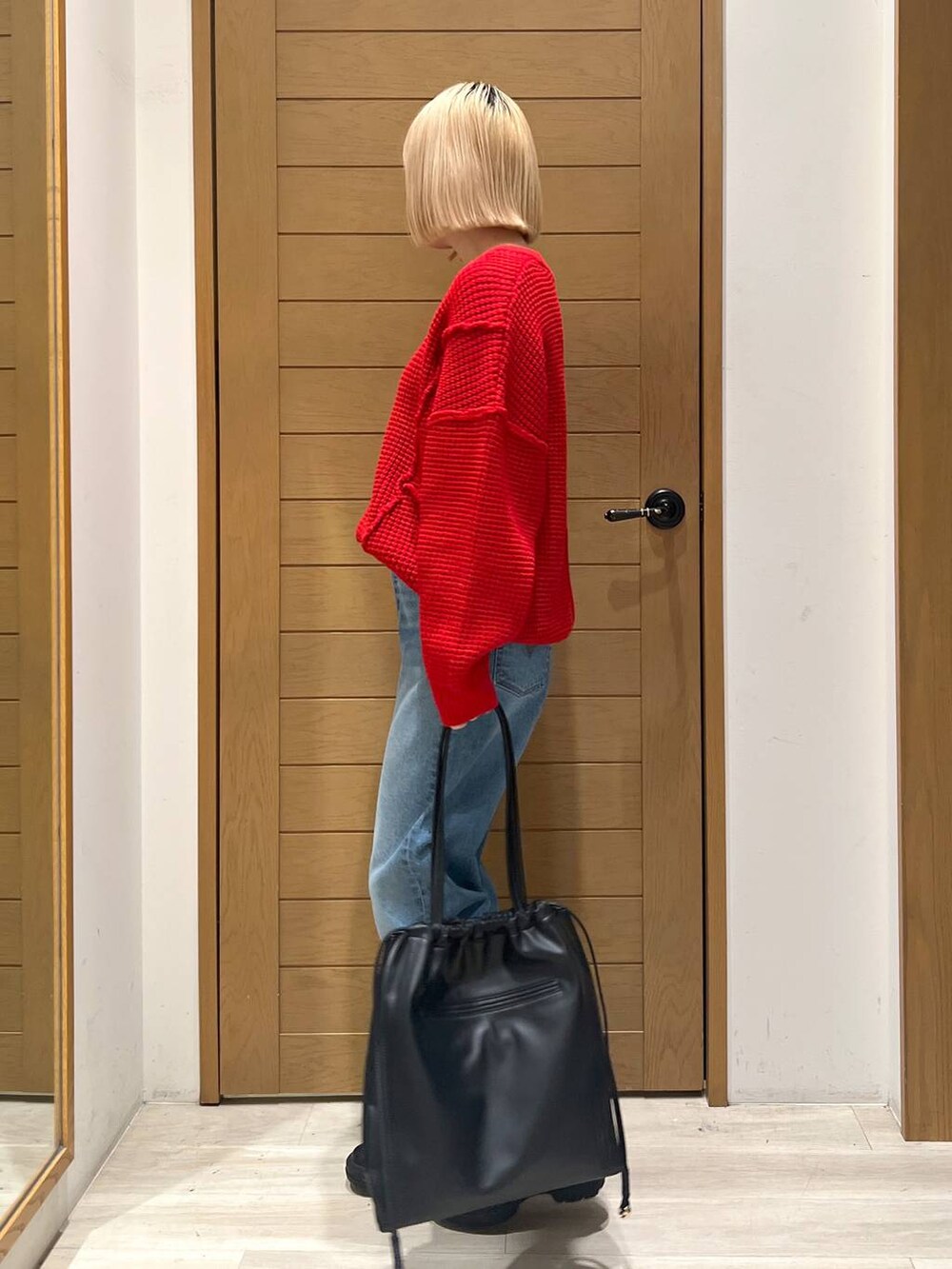 ブルー系のデニムパンツ、レッド系のニット/セーターを着用したレディースの冬コーディネートの3枚目の写真