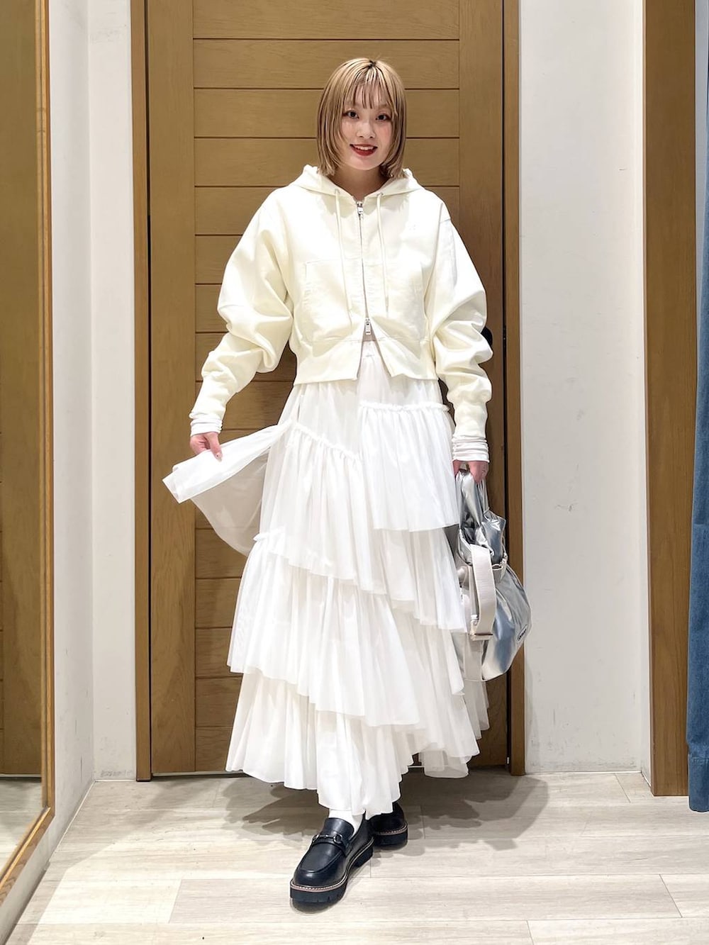 シルバー系のトートバッグ、ブラック系のローファー、ホワイト系のTシャツ/カットソーを着用したレディースの春コーディネートの2枚目の写真