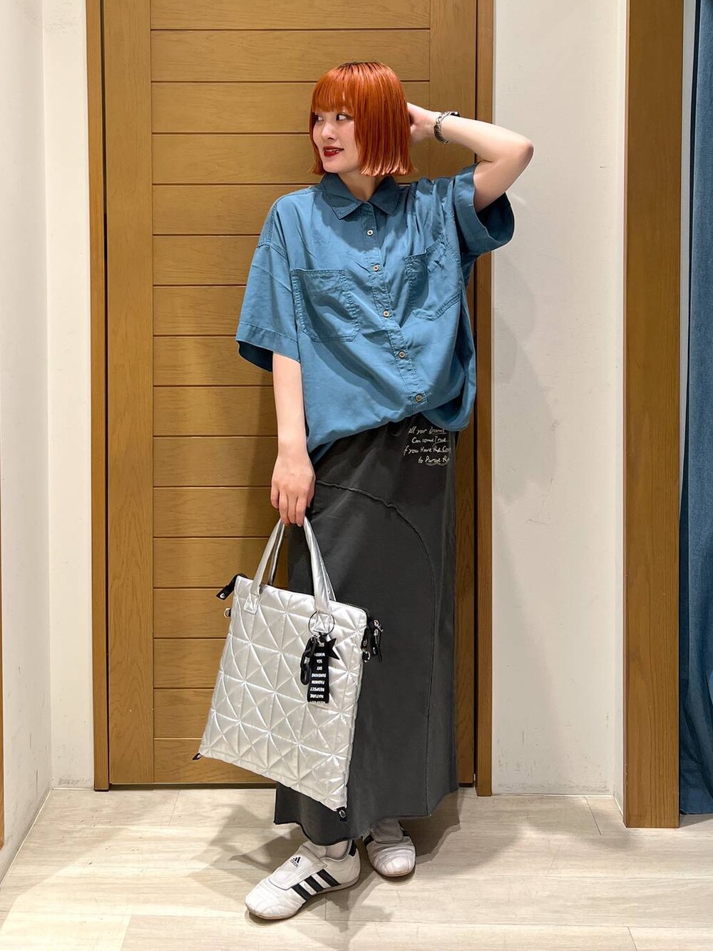 ブルー系のシャツ/ブラウス、グレー系のスカート、シルバー系のトートバッグを着用したレディースの夏コーディネートの3枚目の写真