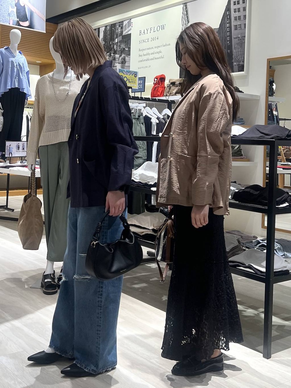 ブルー系のデニムパンツ、ブラック系のハンドバッグ、ブラック系のパンプスを着用したレディースの春コーディネートの3枚目の写真