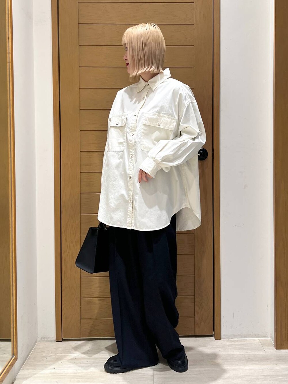 ブラック系のハンドバッグ、ブルー系のその他パンツ、その他のローファーを着用したレディースの冬コーディネートの2枚目の写真