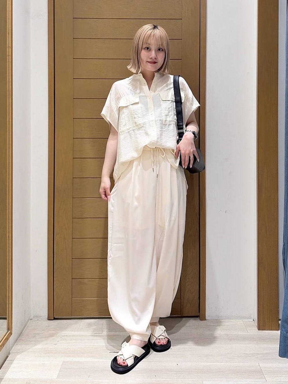 ベージュ系のその他パンツ、ホワイト系のシャツ/ブラウス、ホワイト系のサンダルを着用したレディースの夏コーディネートの4枚目の写真