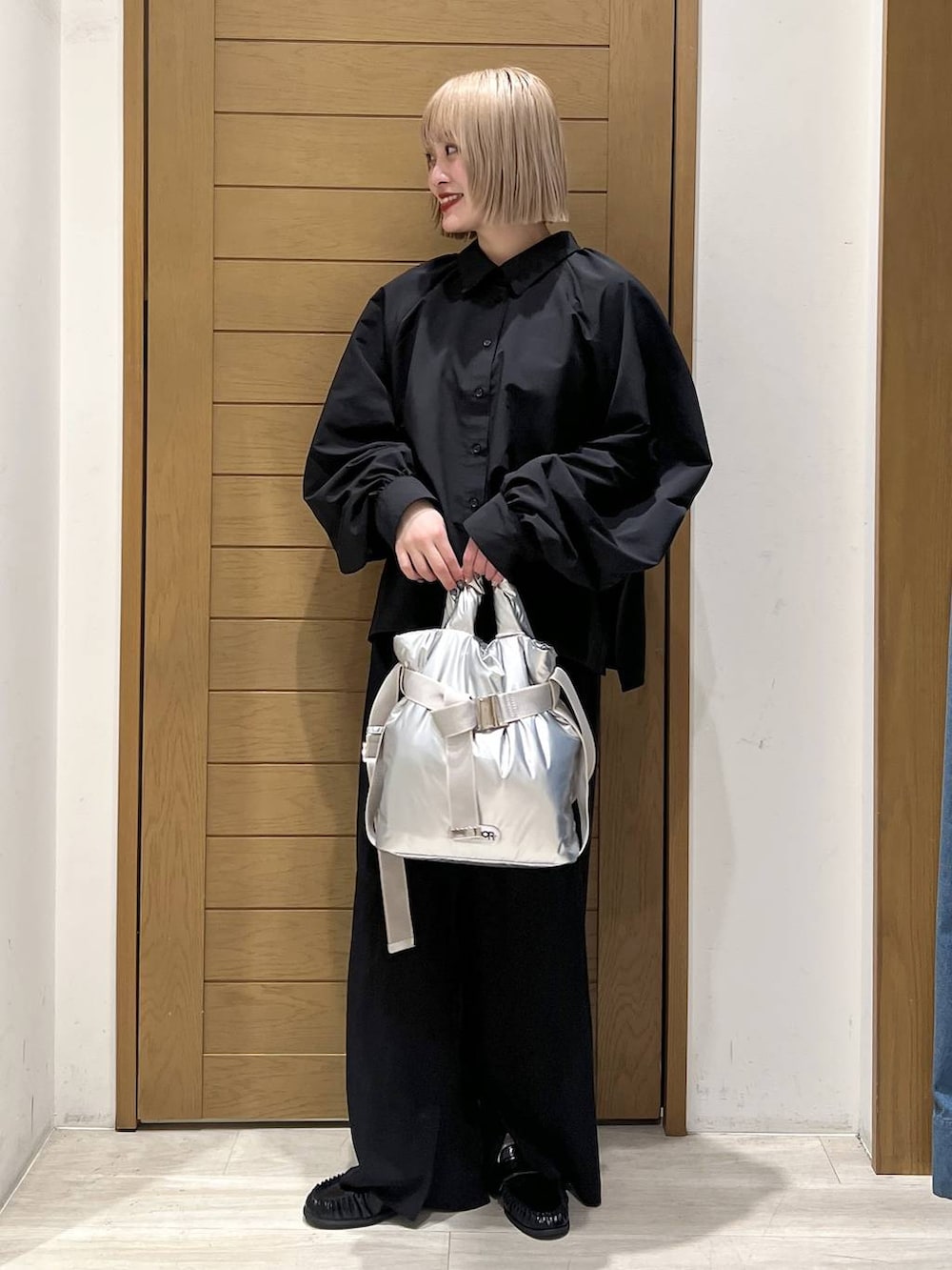 シルバー系のトートバッグ、ブラック系のローファー、ブラック系のその他パンツを着用したレディースの冬コーディネートの2枚目の写真