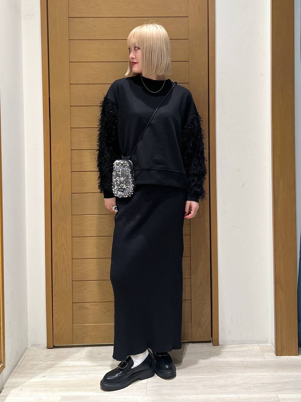 グレー系のショルダーバッグ、その他のローファー、ブラック系のスカートを着用したレディースの冬コーディネートの3枚目の写真