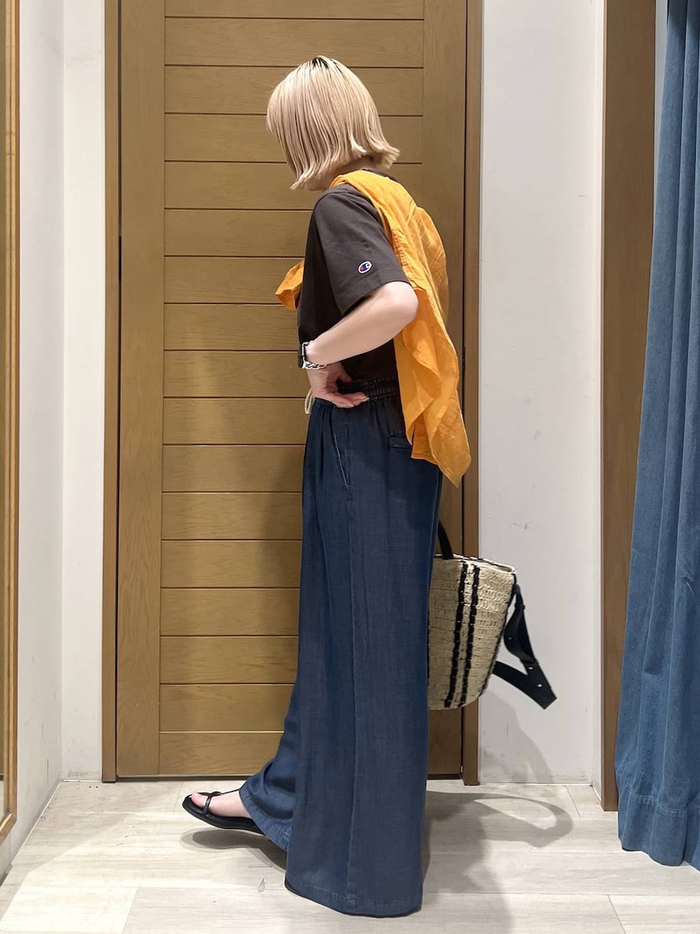 ブラック系のTシャツ/カットソー、オレンジ系のシャツ/ブラウス、ブルー系のデニムパンツを着用したレディースの春コーディネートの3枚目の写真