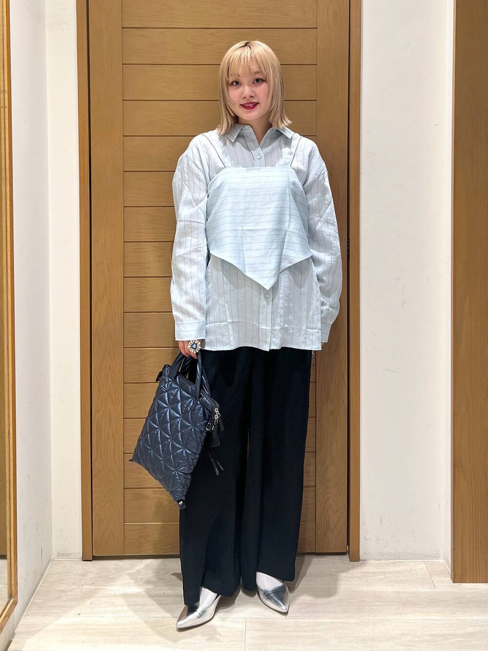 シルバー系のパンプス、ブラック系のその他パンツ、ブルー系のハンドバッグを着用したレディースの春コーディネートの6枚目の写真