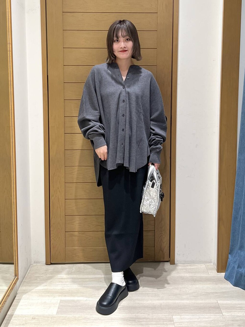 グレー系のカーディガン/ボレロ、シルバー系のショルダーバッグ、ブラック系のサンダルを着用したレディースの秋コーディネートの6枚目の写真