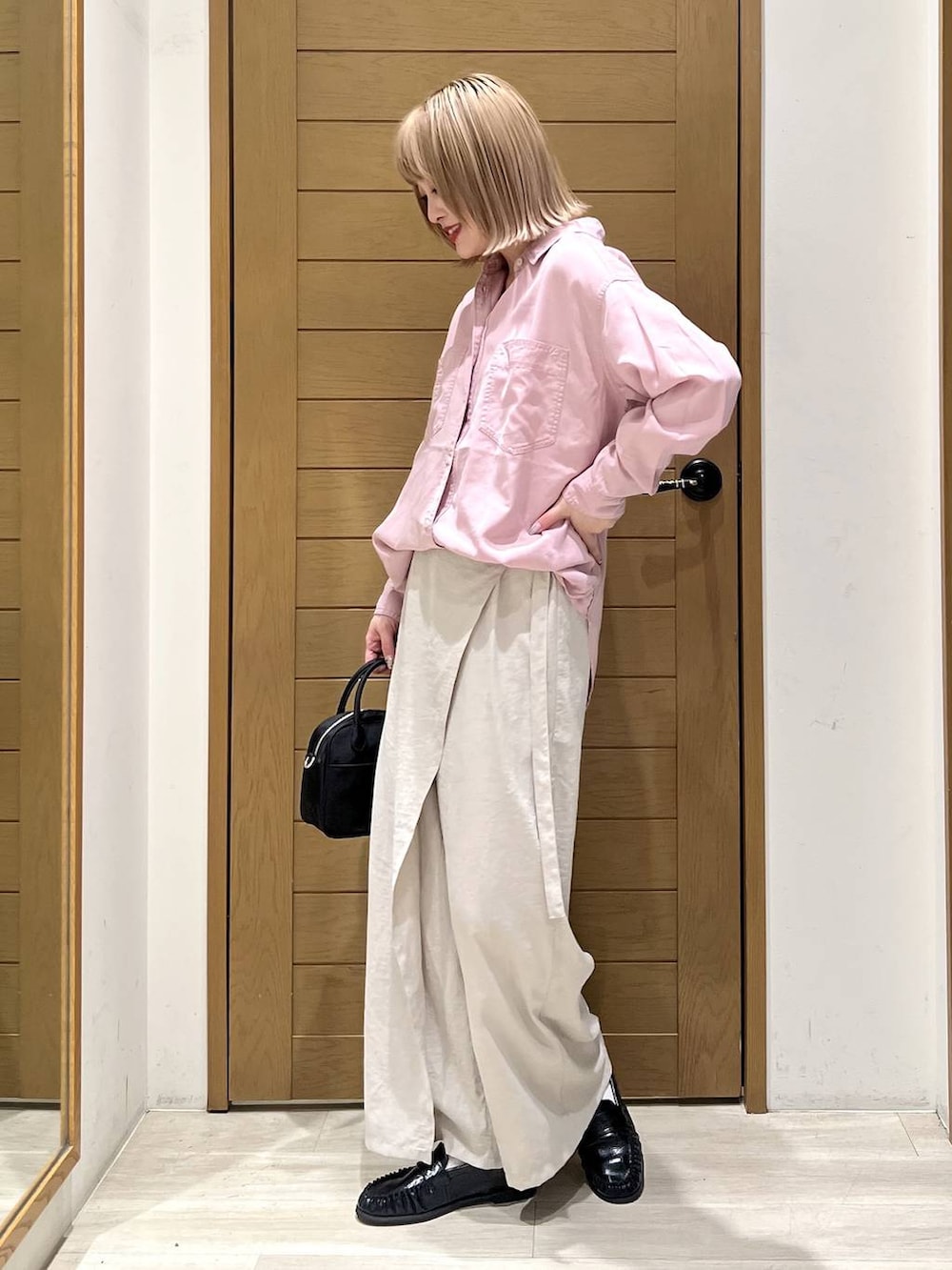 ピンク系のシャツ/ブラウス、ブラック系のハンドバッグ、ブラック系のローファーを着用したレディースの春コーディネートの4枚目の写真