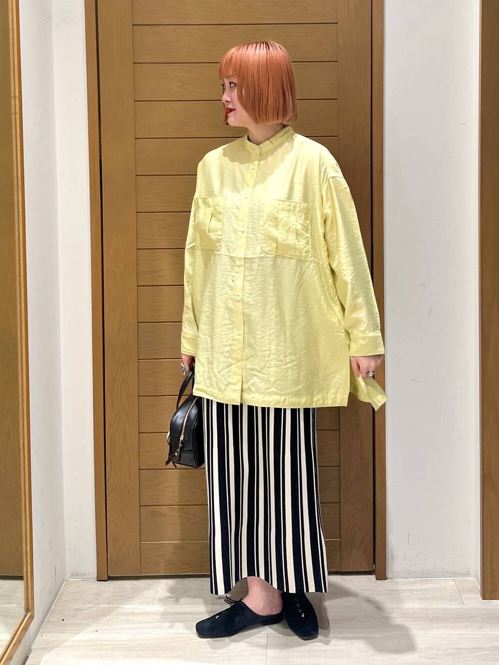 イエロー系のシャツ/ブラウス、ブラック系のショルダーバッグ、ブラック系のその他シューズを着用したレディースの春コーディネートの3枚目の写真